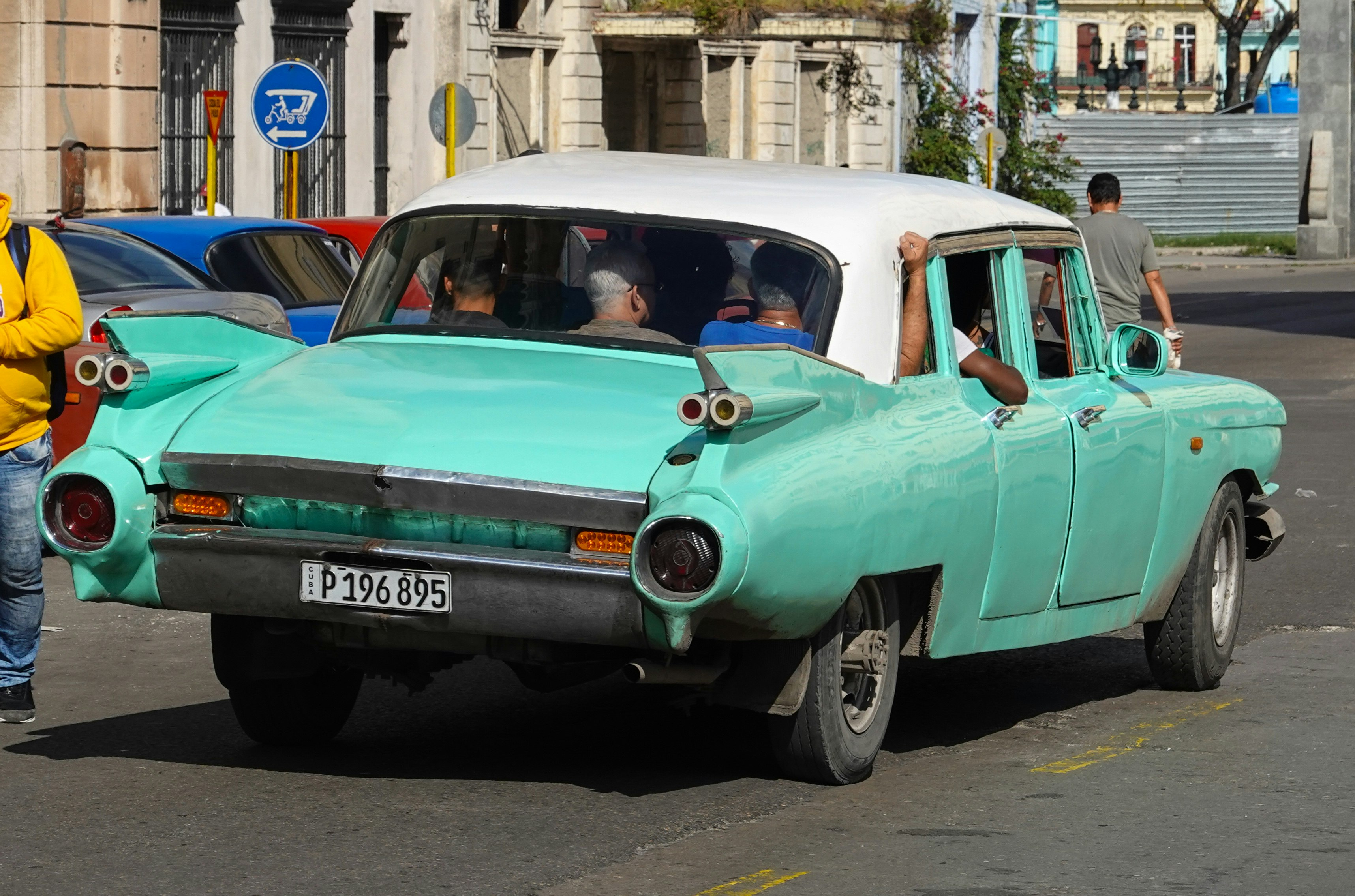 teal and white vintage car on road during daytime